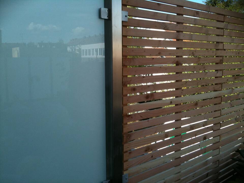 Sichtschutz-Zaun aus Milchglas und Holz.