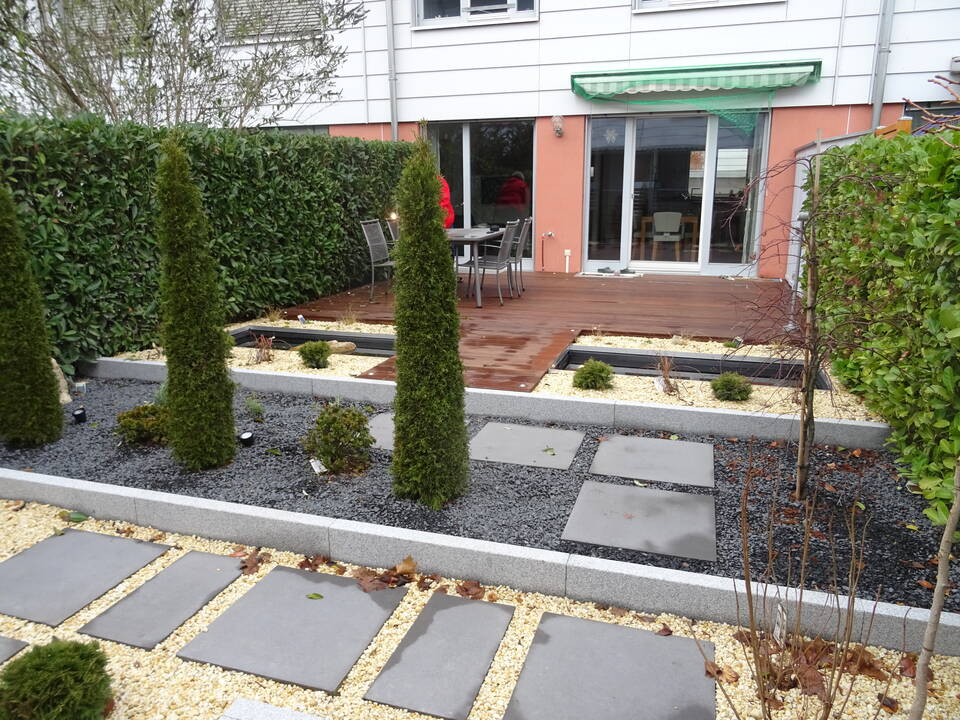 Terrassen-Gestaltung in Fürth: Kleiner Reihenhausgarten mit moderner Holzterrasse und Steingarten