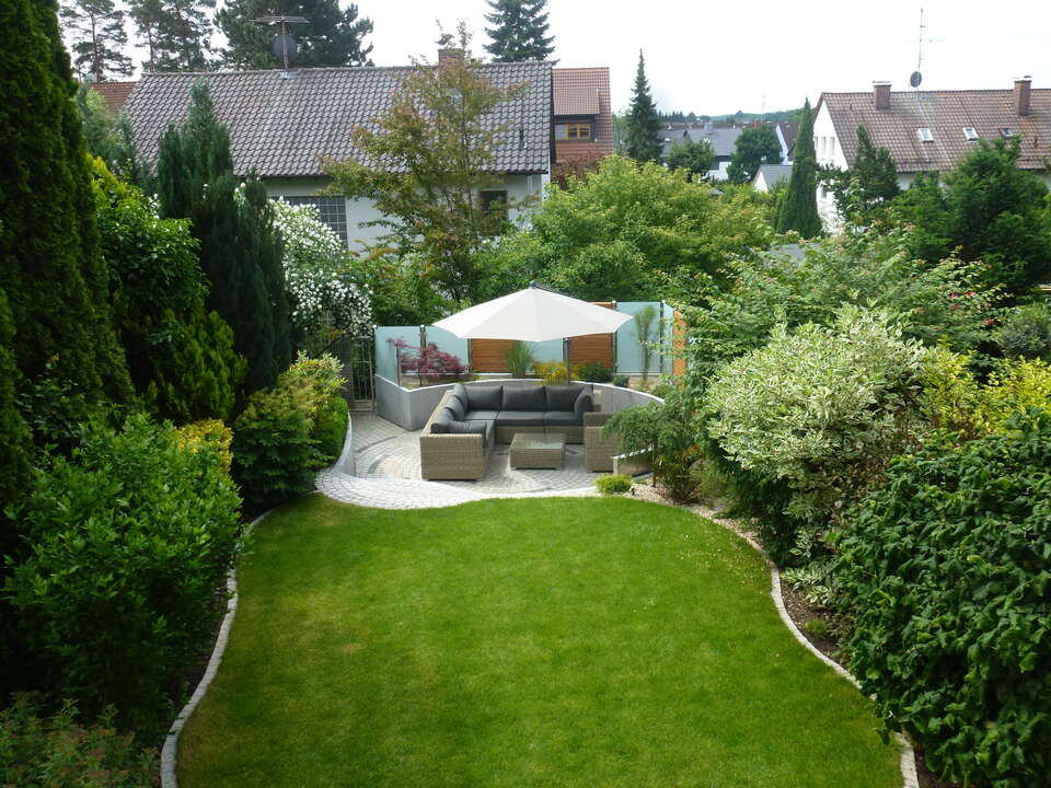 Überblick über die gesamte Gartengestaltung in Fürth: Rasenfläche, Bäume und Büche, Garten-Lounge und Sichtschutz
