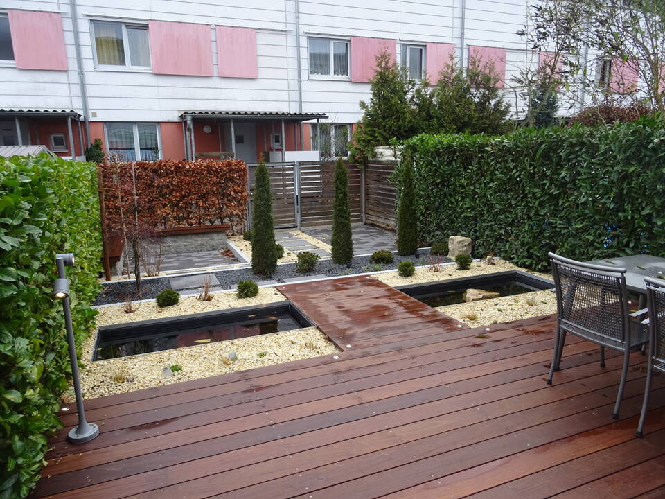 Gartengestaltung in Fürth: Reihenhaus-Garten mit Holzterrasse, Steingarten, Pflaster, Wasserflächen und Hecke