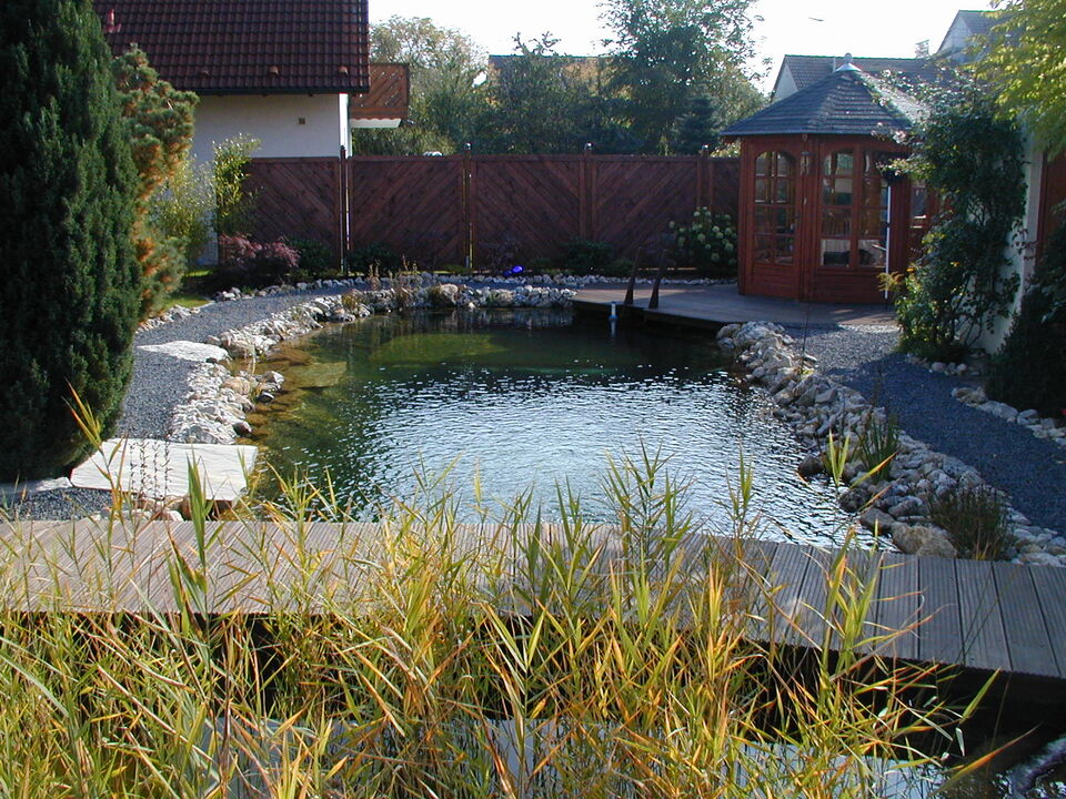 erdmodellierter Schwimmteich bei Ansbach mit hölzerner Teichbrücke (Holzdeck)