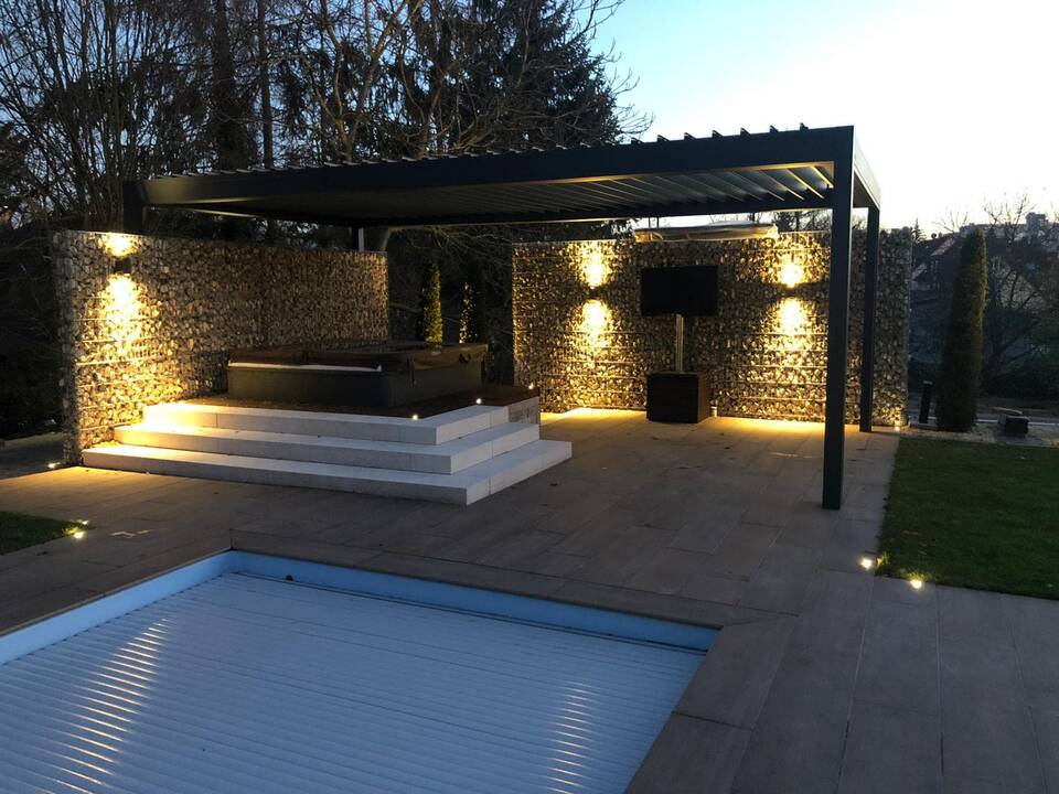 Spa-Gartengestaltung mit Pool, Whirlpool, Lamellendach, Gartenbeleuchtung und Sichtschutz aus Gabionen in Fürth bei Nacht