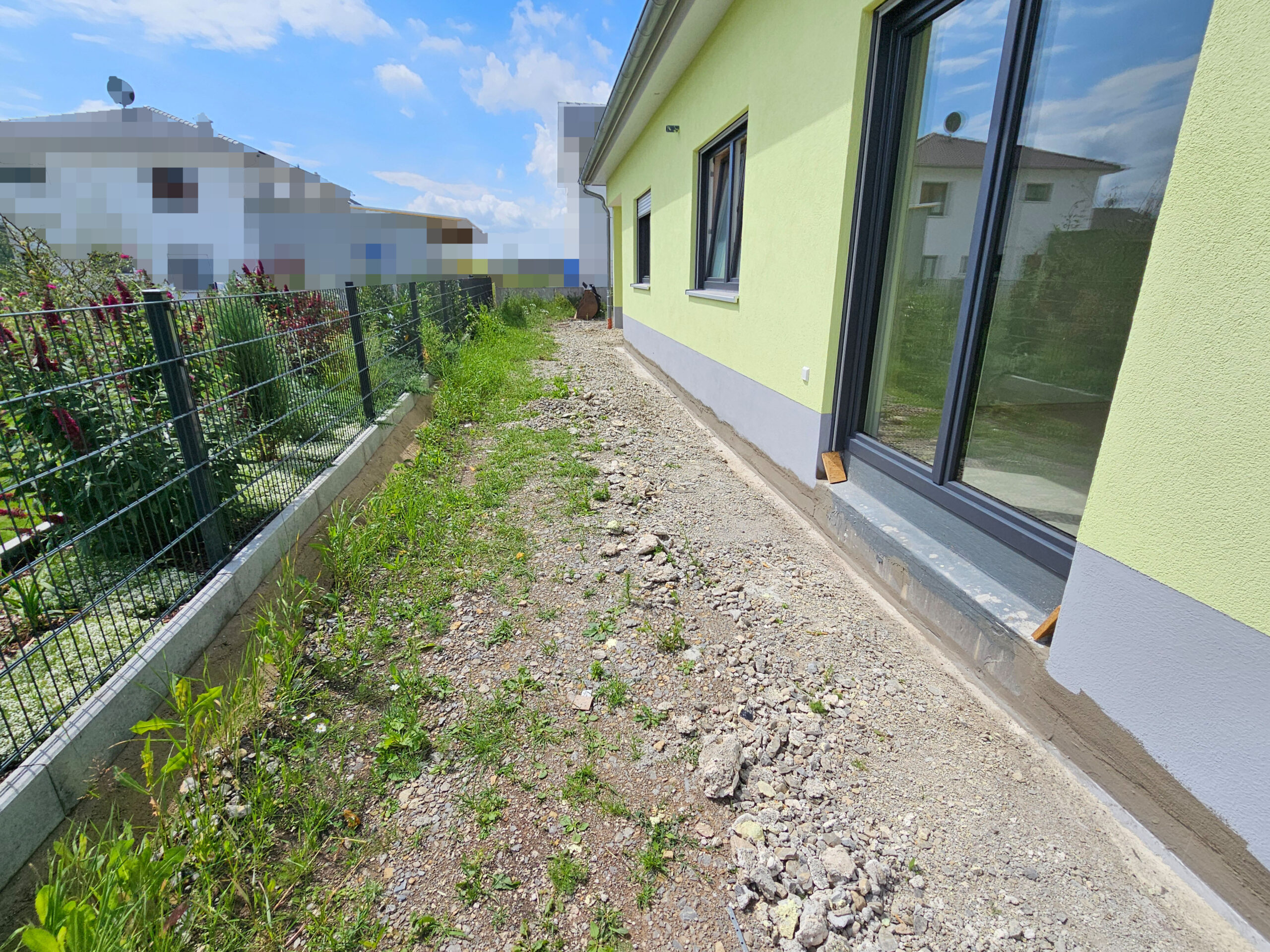 Gartenbau in Ansbach: Vorher-Bild eines schmalen, noch nicht angelegten Gartens neben dem Haus.