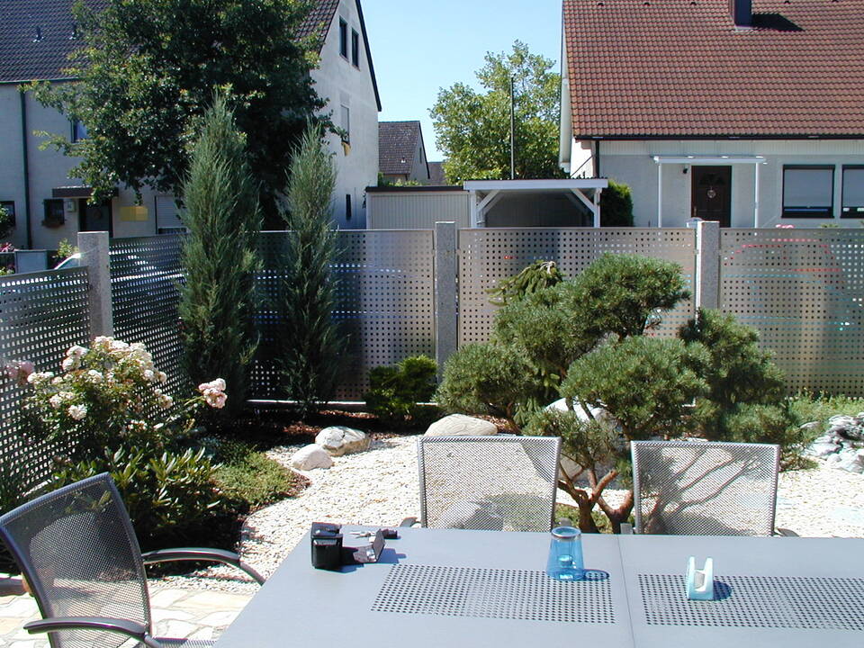 Gartenzaun aus Edelstahl-Lochblech mit Zaunpfählen aus Granit