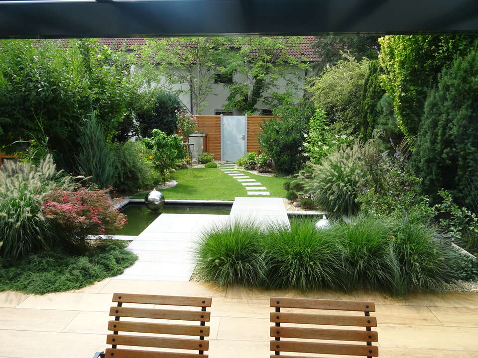 Holz-Gartenzaun mit Milchglas-Gartentür in einem Reihenhaus-Garten.