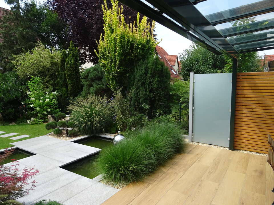 Terrassen-Sichtschutz zwischen 2 Reihenhäusern, daneben Maschendraht-Gartenzaun.